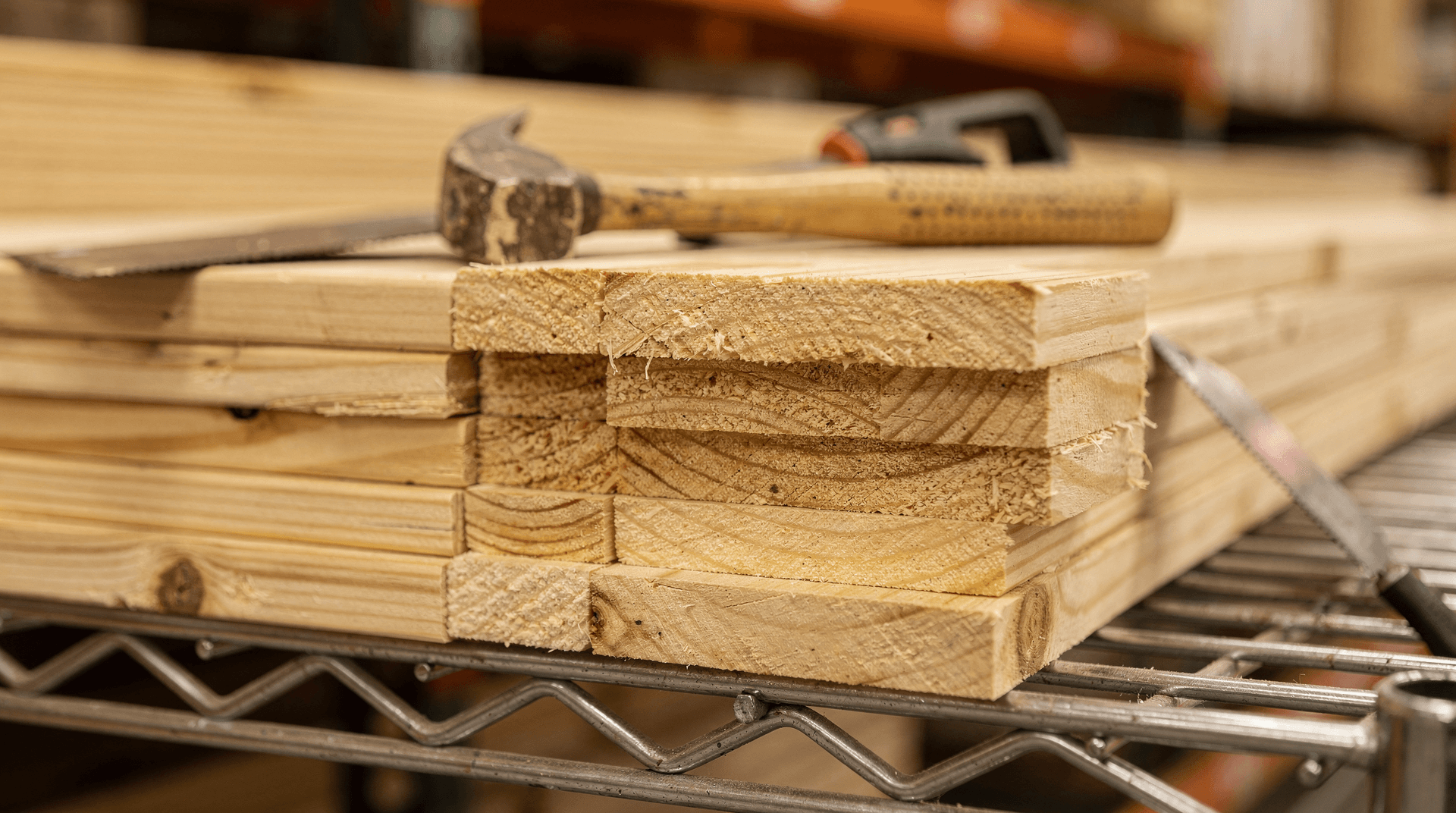 Close-up of stacked lumber and construction tools on a retail store shelf, showing home improvement materials