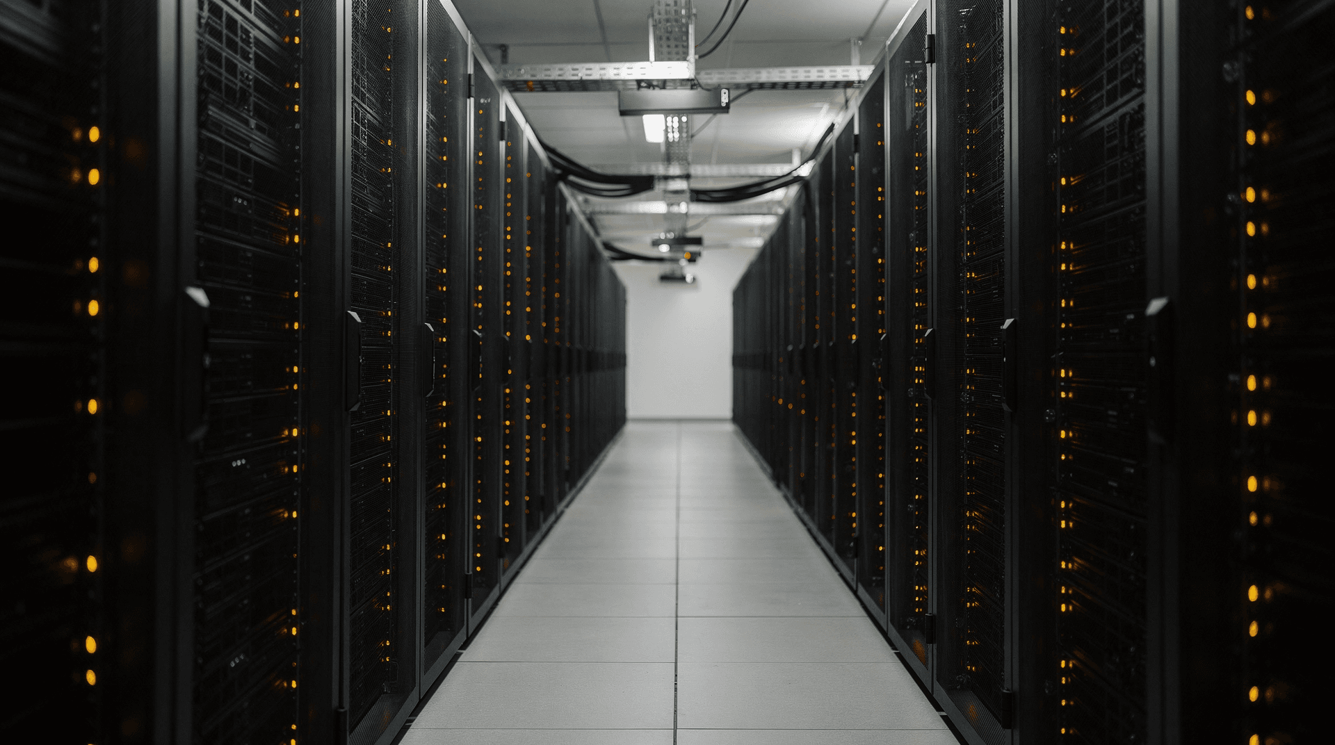 Rows of server racks in a data center illuminated by amber LED lights