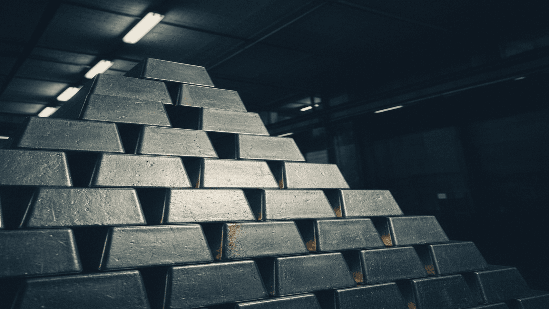 Stacked silver bullion bars under dramatic vault lighting, dark negative space reserved above.