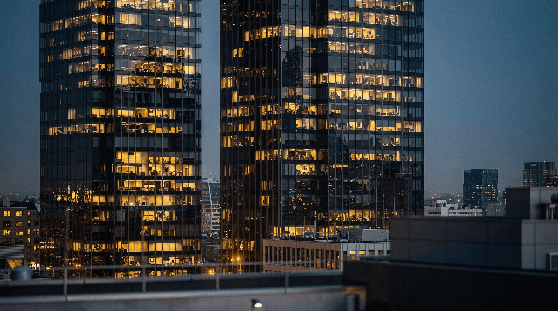 Financial district skyscrapers at dusk with many lit windows