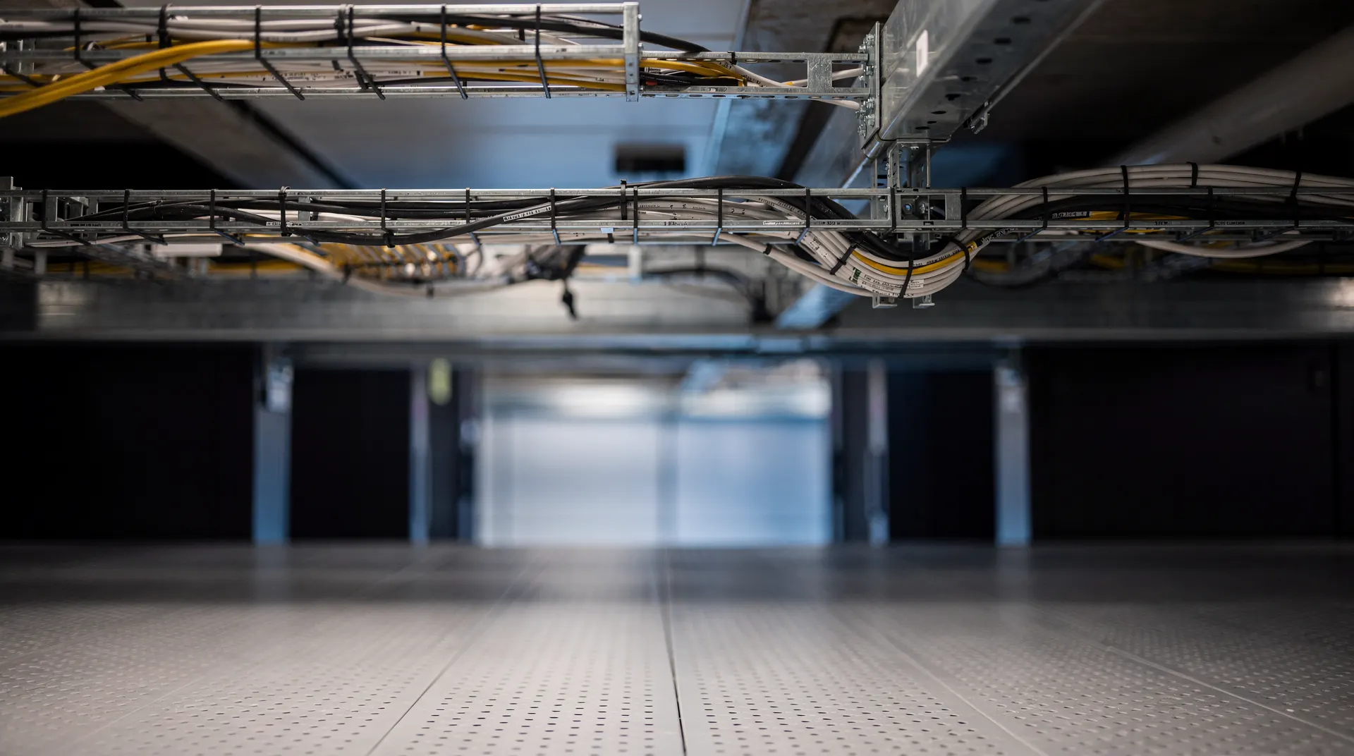 Populated server racks face empty bays along a dimly lit data-center aisle.