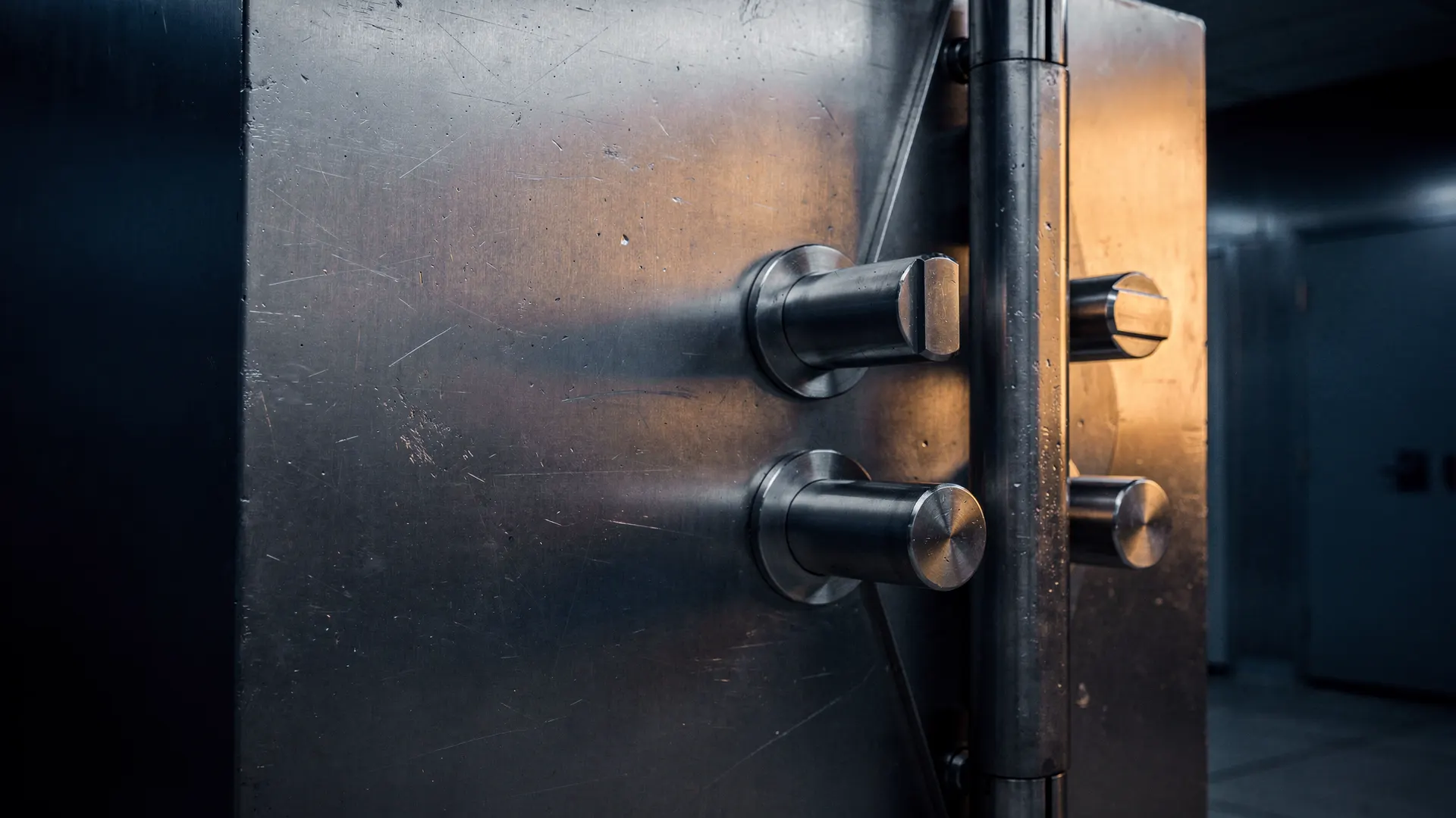 Partially open steel vault door in a dim, secure room