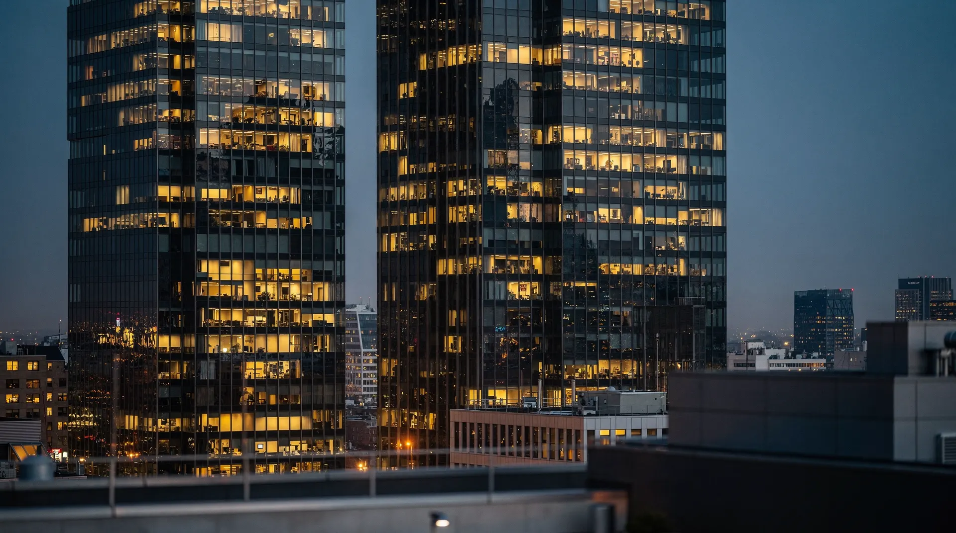 Financial district skyscrapers at dusk with many lit windows