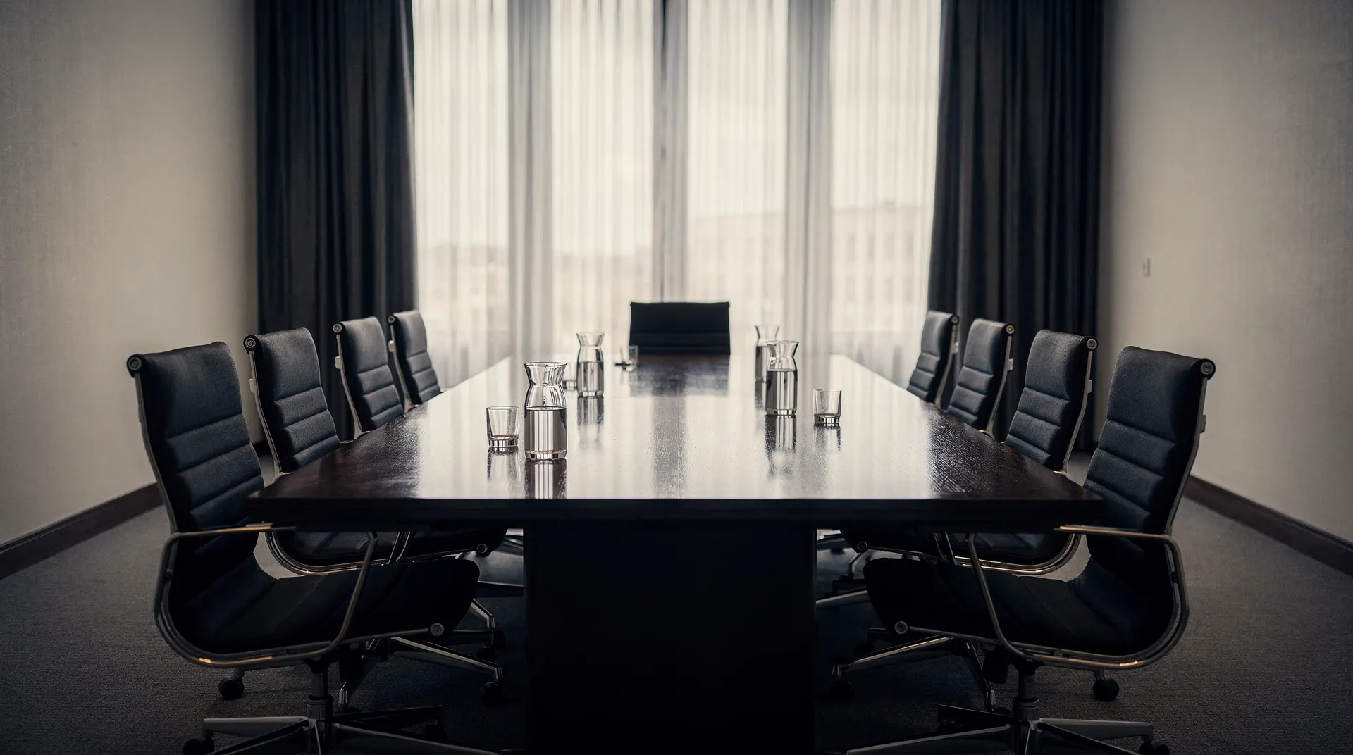 Empty policy meeting room with chairs around a long table in soft window light.