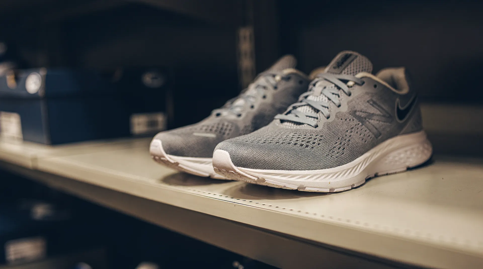 Unbranded running shoes sit on a sparse store shelf beside empty display space.