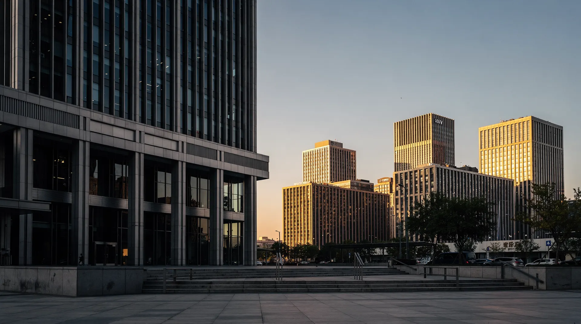 A shadowed office tower rises beside a wider cluster of sunlit bank and corporate buildings.