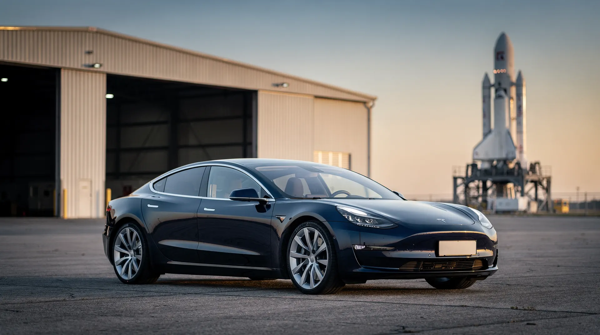 An unbadged electric sports car sits near an aerospace hangar, with an unmarked rocket in the distance.